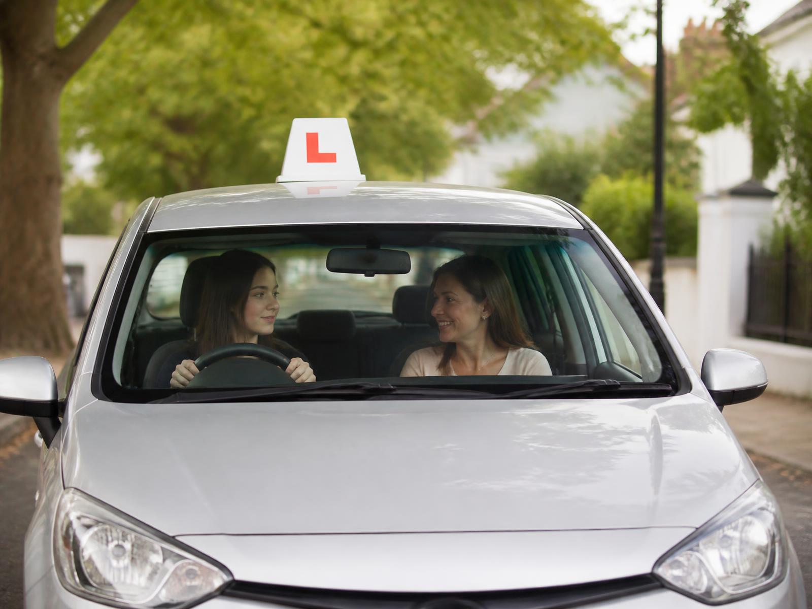 A DriveRight Academy instructor teaching a learner driver in a modern car on a West London street
